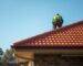Roof repair Perth tradesperson inspecting terracotta roof tiles and ridge capping on a sunny day
